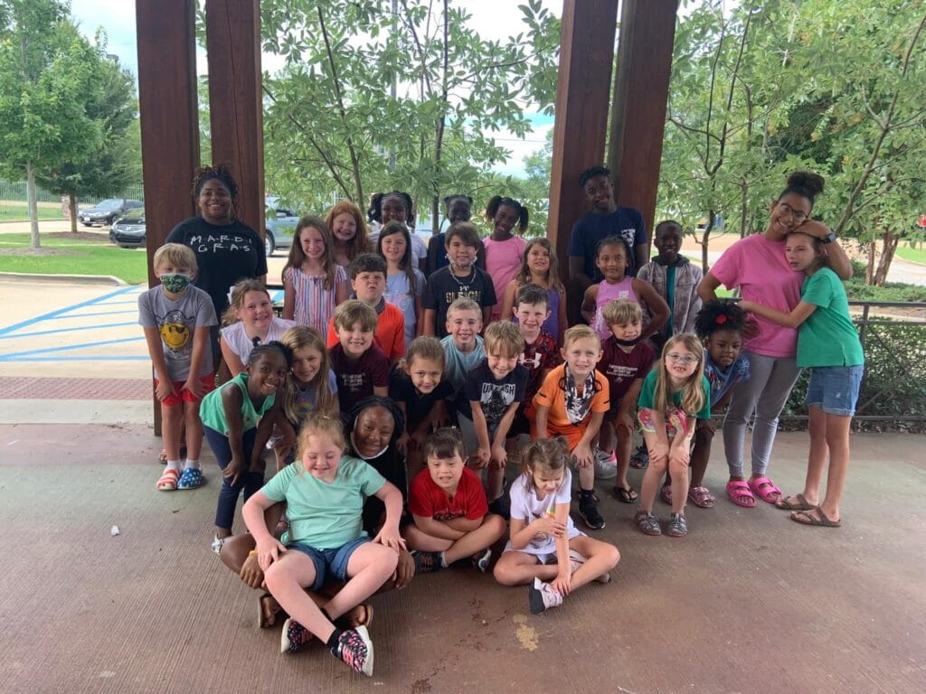 Group of kids in rows outside smiling