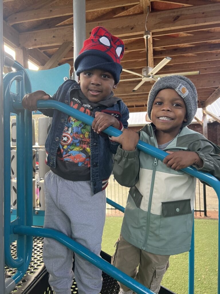 Three smiling children outside